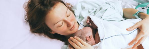 A new mother in a hospital bed with her newborn