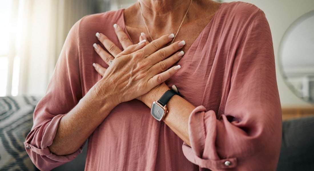 Woman holding two hands over her chest