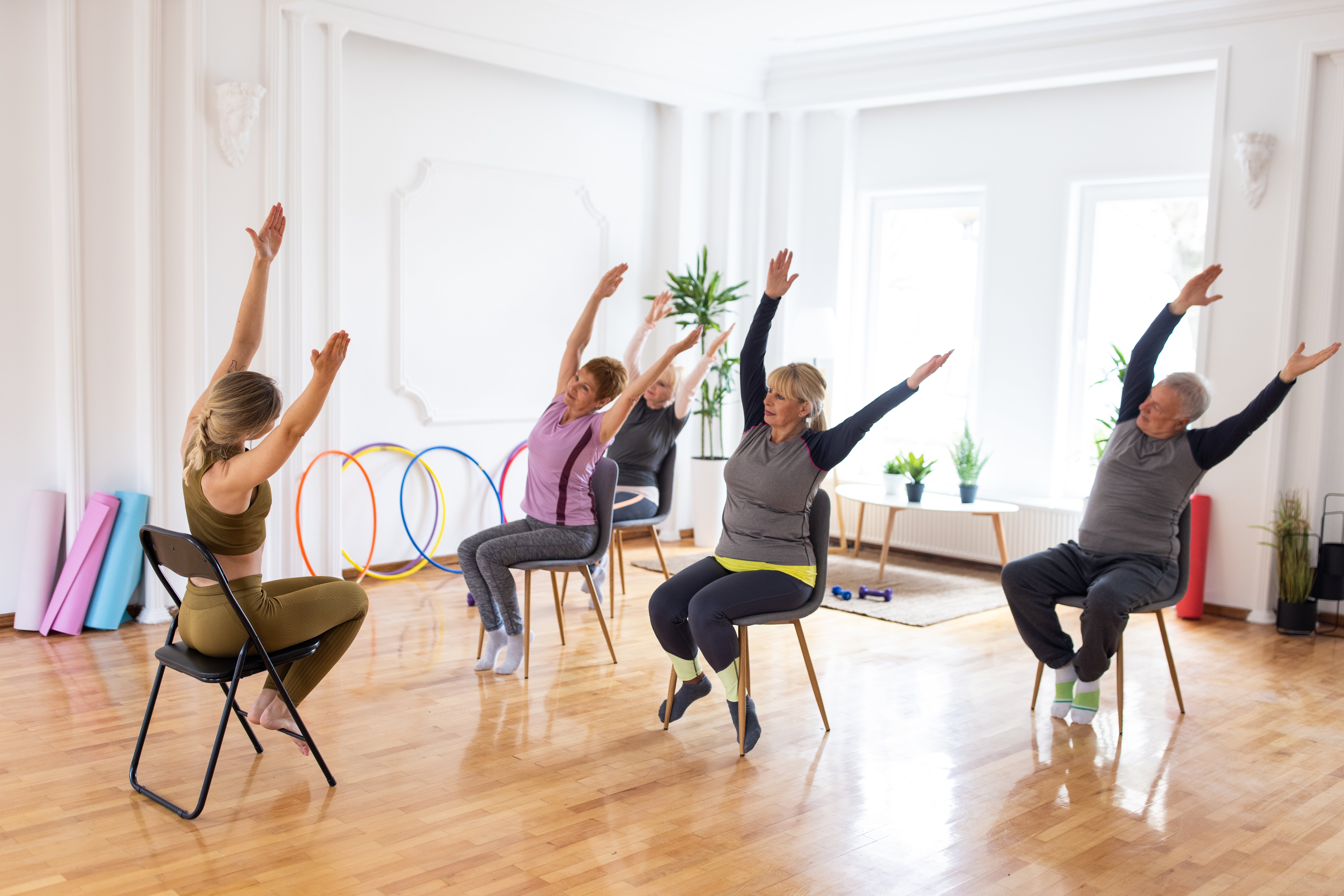 A group of older adults doing chair yoga together